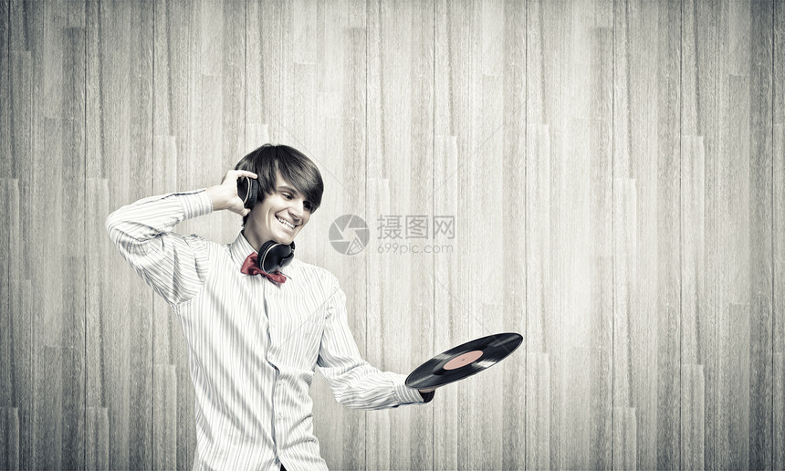 迪斯科DJ轻人DJ戴着耳机着盘子图片