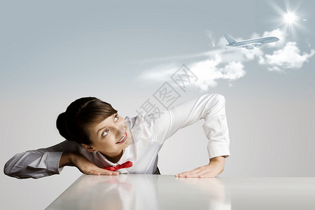 空中小姐轻的女人靠桌子上方,看着天空中的飞机图片