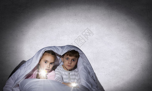 孩子们的噩梦孩子们用手电筒坐毯子下的床上图片