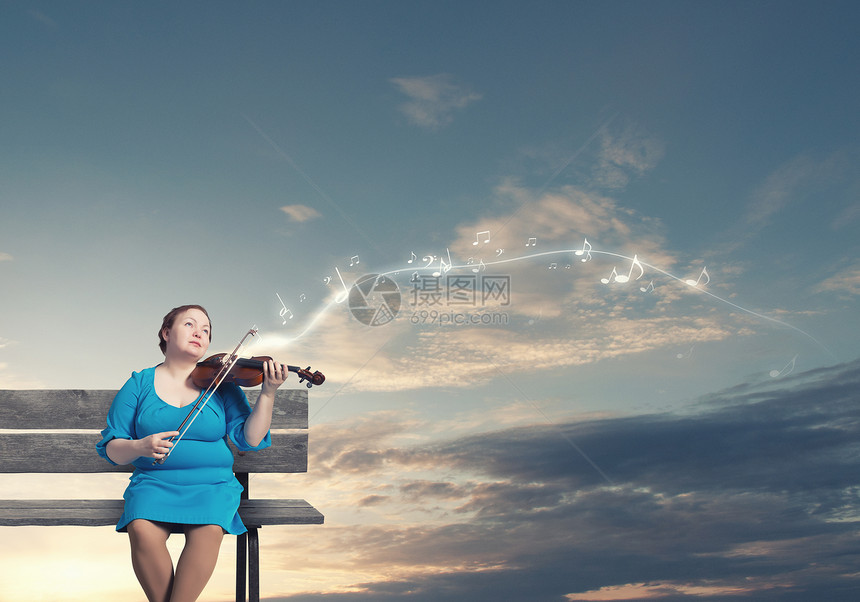 超重问题穿着蓝色连衣裙的中胖女人坐长凳上拉小提琴图片