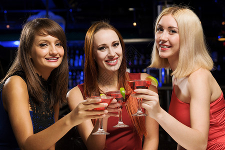 周末派三位优雅的女士夜总会喝鸡尾酒高清图片