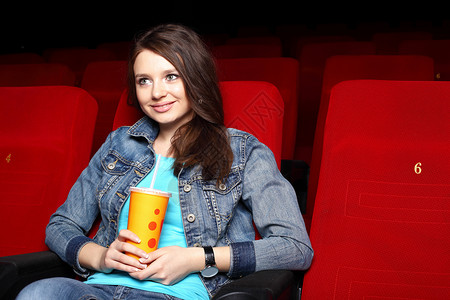 轻女孩坐电影院看电影图片