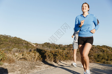 运动跑步者海滩上慢跑,她的搭档锻炼适合女健身模式慢跑沿海洋与她的伴侣图片
