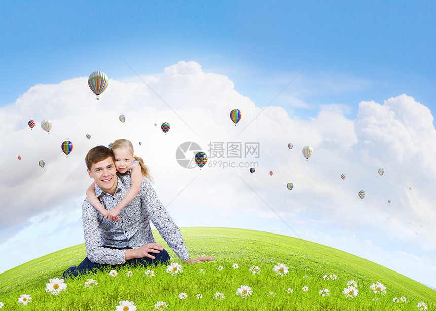 快乐的父母父亲女儿坐草地上的幸福家庭图片