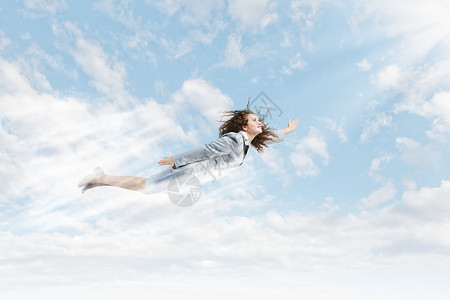 会飞的女轻漂亮的女商人蓝天上飞翔图片