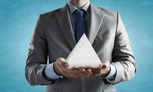 商业金字塔系统把金字塔握手中的商人的特写图片