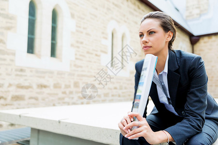 商业女人户外微笑的肖像轻商业女户外坐着思考的肖像图片