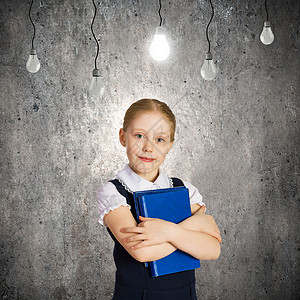 神童可爱的学校女孩靠灰色的墙上,挂着灯泡图片