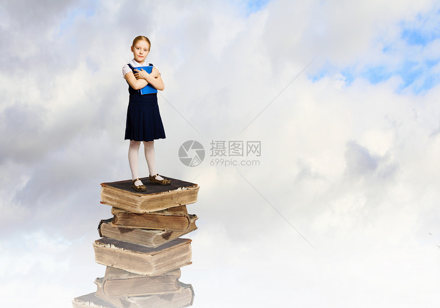 教育理念可爱的学校女孩站堆书上的形象图片