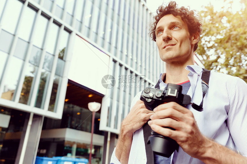 城市的男游客快乐的男游客带着相机城市里散步图片