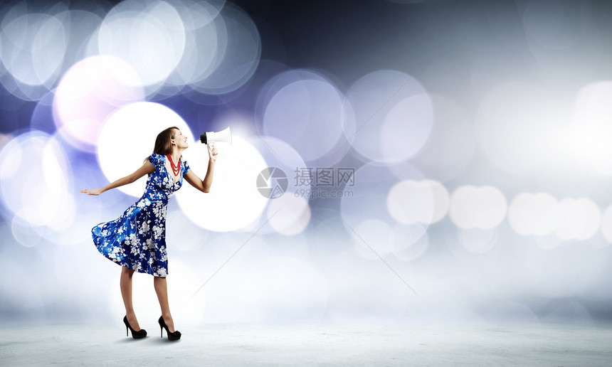 扩音器的女人穿着蓝色衣服的轻女人用扩音器说话图片