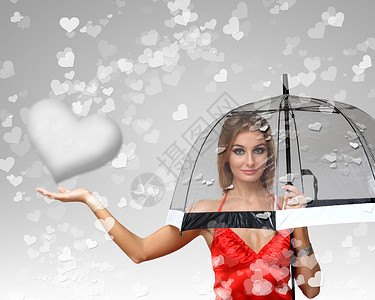 漂亮的轻女人带着雨伞背景上的心图片