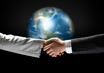 商务握手的形象商务握手黑色背景下与地球仪图像图片