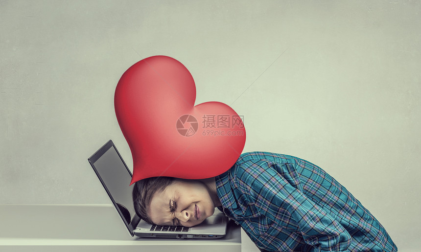 疲惫的女孩压力下女程序员用爱的心压笔记本电脑上图片