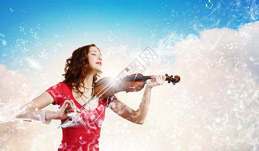 女小提琴手轻迷人的女人穿着红色连衣裙拉小提琴图片