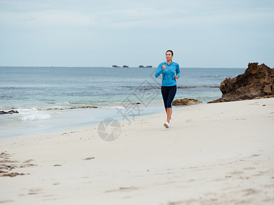 运动的轻女人海边跑步图片