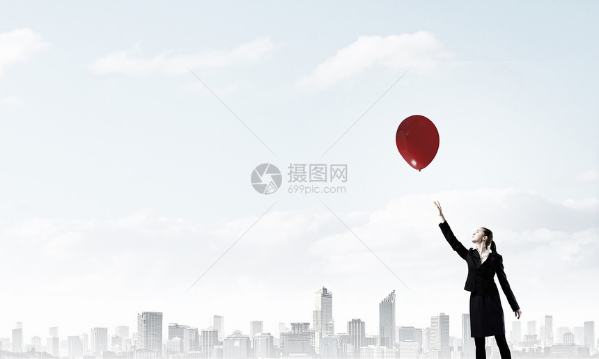 气球的女人轻的女商人伸手触摸天空中的气球图片