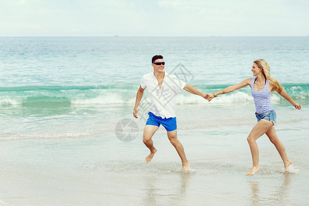 浪漫的轻夫妇海滩上浪漫的轻夫妇海滩上沿着海岸奔跑图片