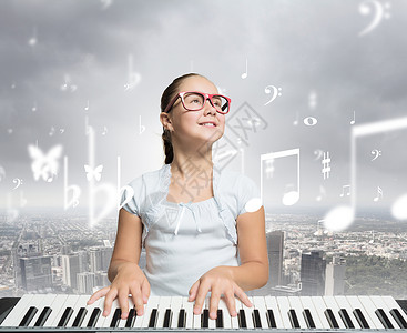 女孩个古老的黑色上演奏轻的女孩用红色的眼镜数字钢琴上挑逗图片