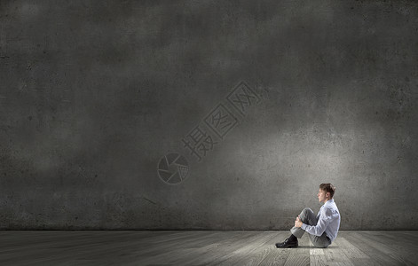 商人轻沮丧的商人独自坐空房间的地板上图片