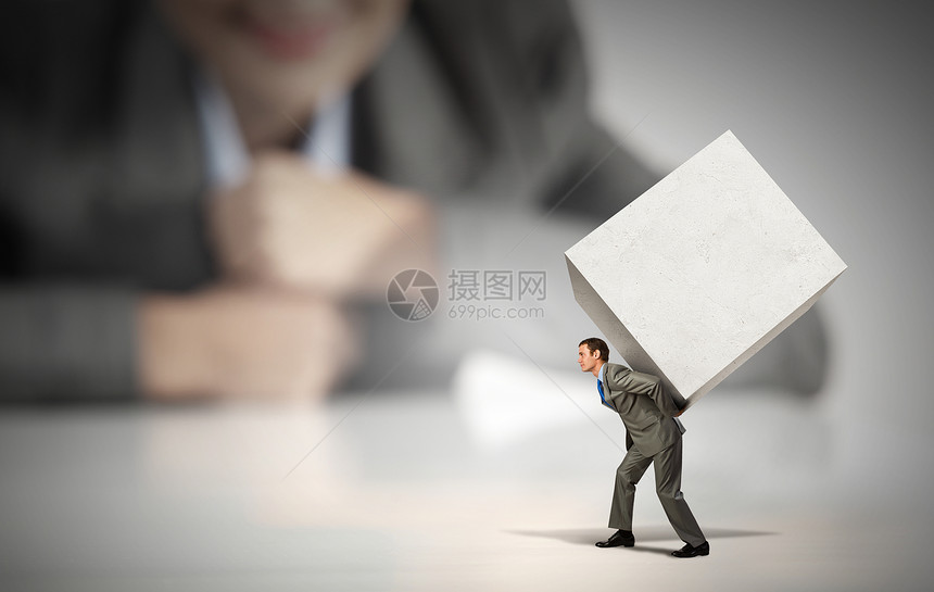 立方体的人女商人看着背着白色立方体的男人的缩影图片