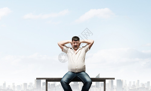胖子坐长凳上,双手合耳胖子图片