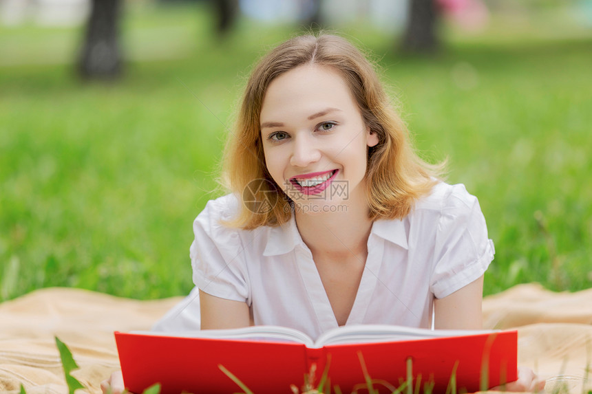 周末野餐轻漂亮的女人夏天公园读书图片
