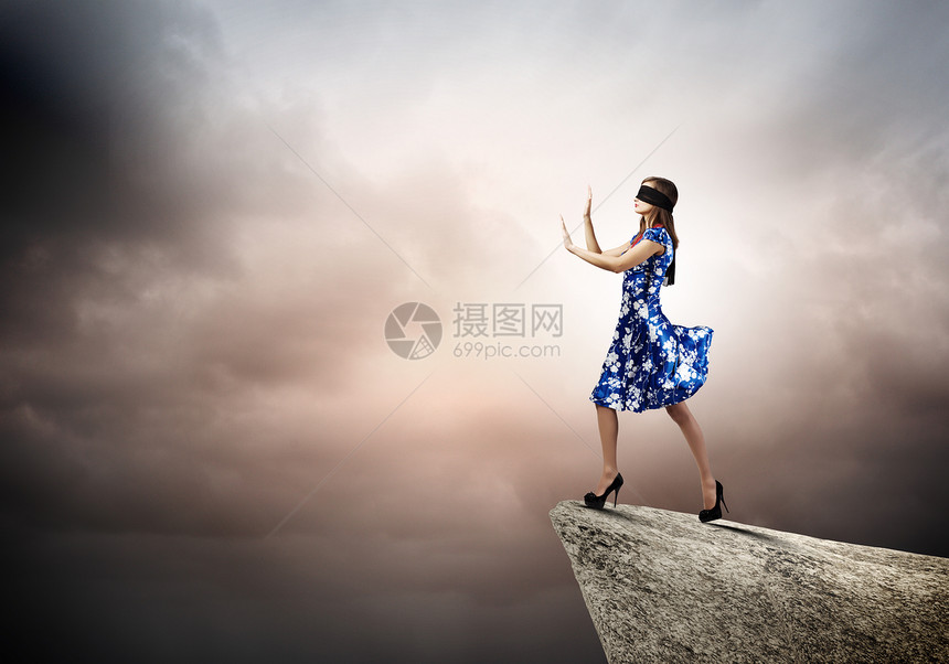 戴眼罩的女人穿着蓝色连衣裙的轻女人站山边图片
