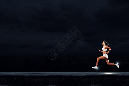 全速前进轻的女运动员黑暗的背景下跑得很快背景图片
