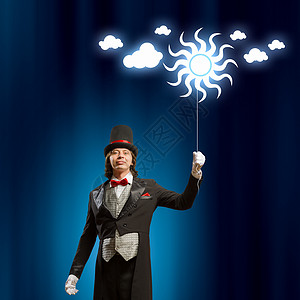 戴帽子的魔术师男子魔术师的形象与气球的颜色背景燕尾服高清图片素材