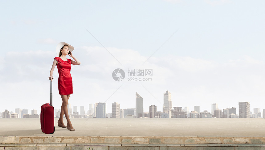 穿红色衣服的女人穿着红色连衣裙的轻女人着红色的行李手机上说话图片