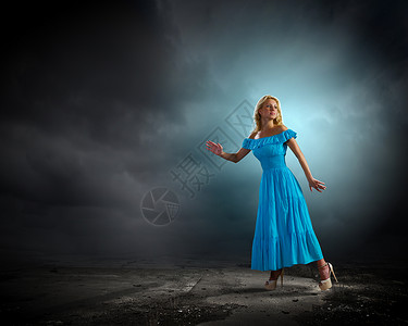 穿蓝色衣服的女士焦急的轻女人穿着蓝色的连衣裙,回头看着担心图片