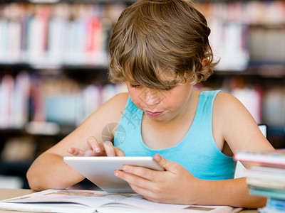 小男孩坐图书馆里着平板电脑小学男孩图书馆里平板电脑图片