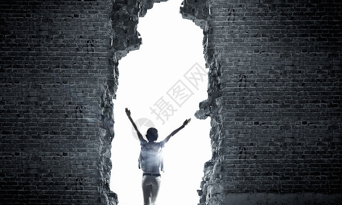 鉴于成功女人的后视镜,双手向上进入墙壁的裂缝背景图片