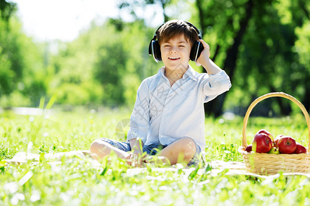 夏天公园里的小快乐男孩戴着耳机大自然的声音图片