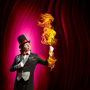 戴帽子的魔术师男子魔术师的形象,魔术与颜色背景火高清图片素材