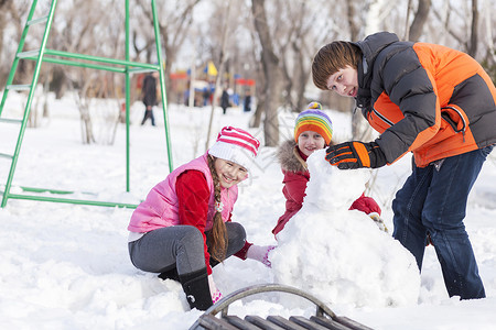 冬天公园里的孩子们玩得很开心,玩雪球冬季活动图片