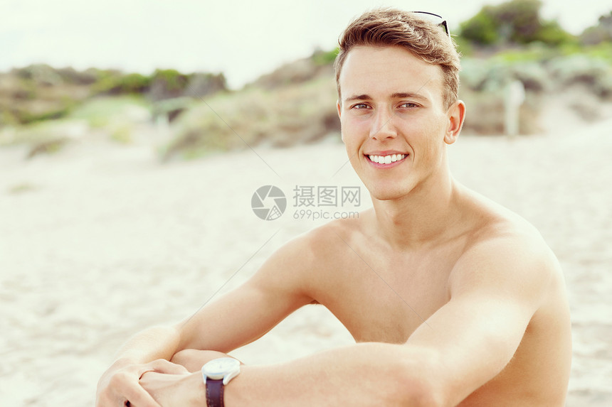 英俊的男人海滩上摆姿势阳光明媚的天,英俊的男人海滩上摆姿势的户外肖像图片