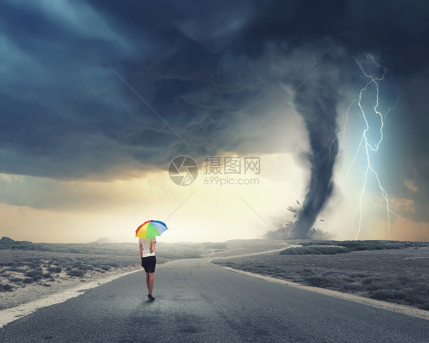 带彩虹伞的女人轻漂亮的女商人带着彩虹五颜六色的雨伞暴风雨中行走图片