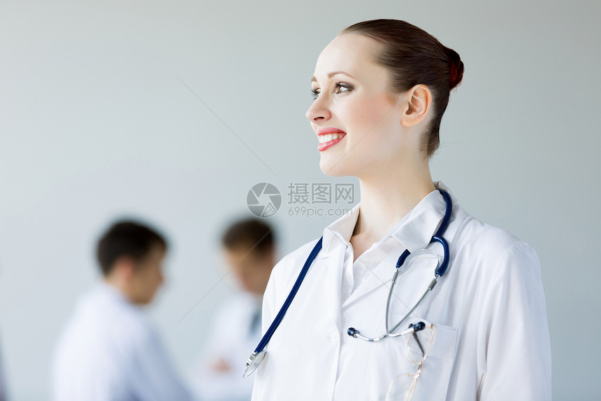轻的女医生吸引力的女医生穿着白色制服,同事背景图片