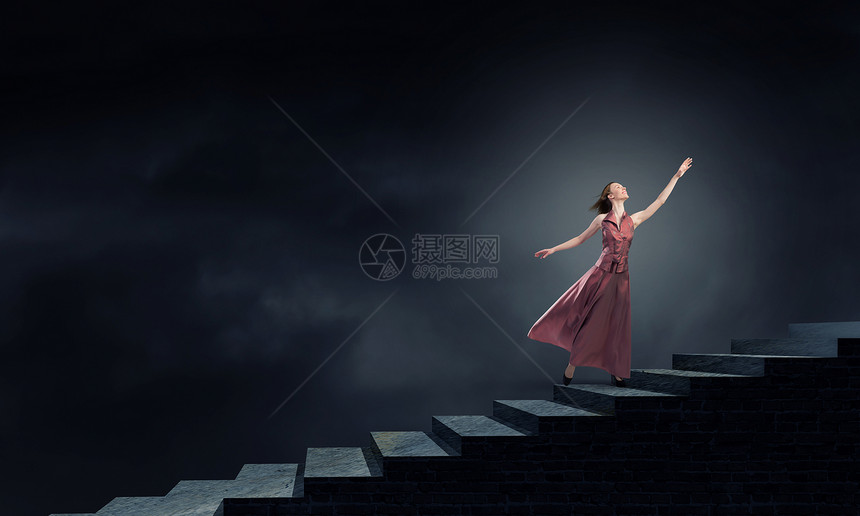 女人楼梯上跑穿着连衣裙的轻金发女人走上楼梯图片
