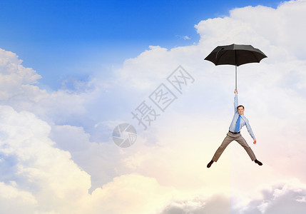 轻的商人伞上高高地飞翔人伞上飞翔图片