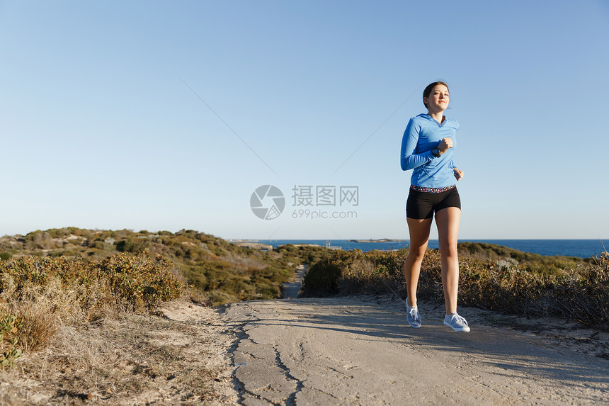 运动跑步者海滩上慢跑锻炼适合女健身模型沿海洋慢跑图片