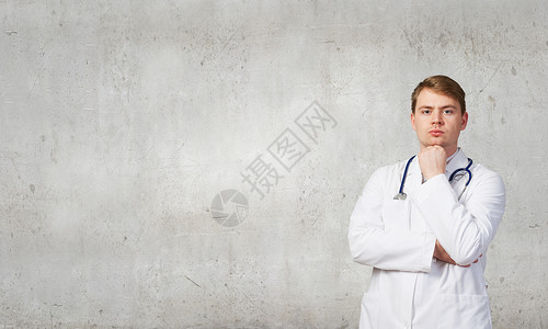 手臂下巴上的自信医生的肖像男阳医生图片