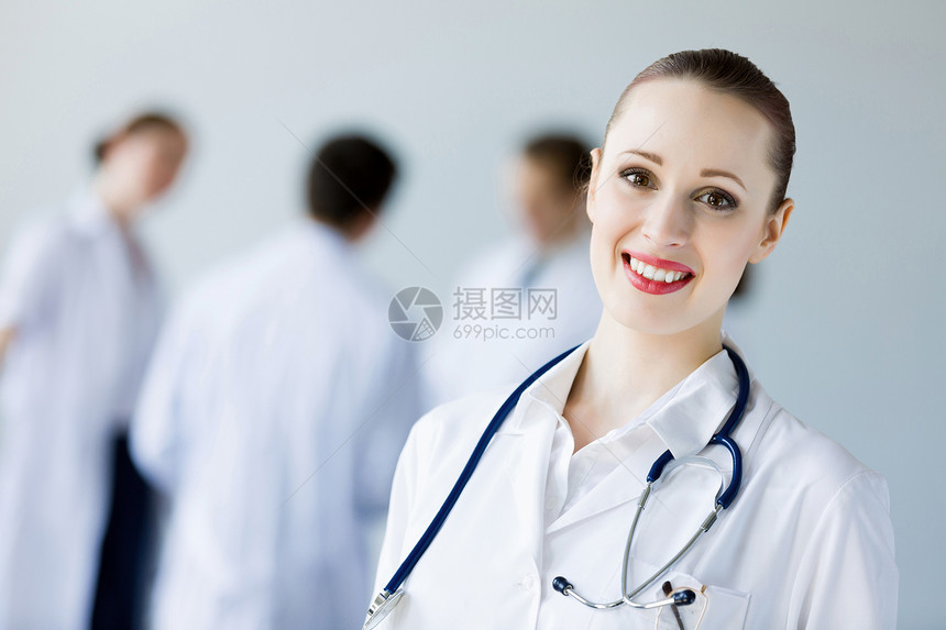 轻的女医生吸引力的女医生穿着白色制服,同事背景图片