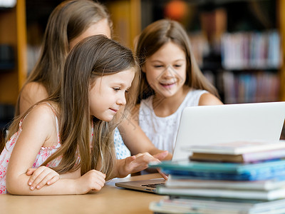 电子书籍图书馆里着笔记本电脑的小女孩图书馆的技术背景