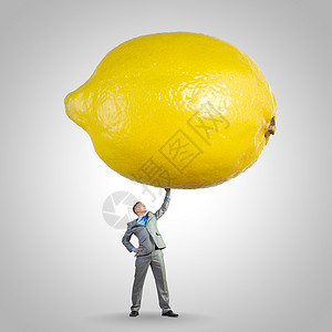 维生素促进健康轻健康的商人举巨大的柠檬头顶图片