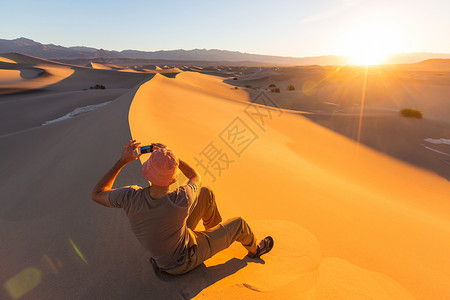 沙漠里的徒步旅行者日出时间高清图片