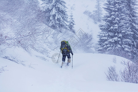 雪鞋行走冬天山上的徒步旅行者背景