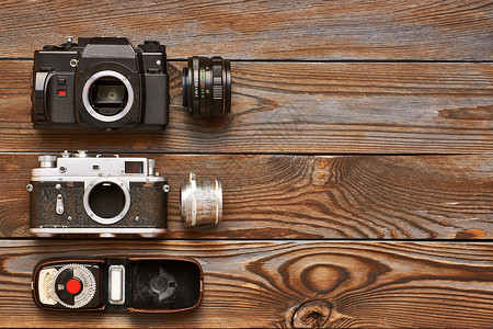 老式的35毫米相机,镜头木制背景上的光表图片